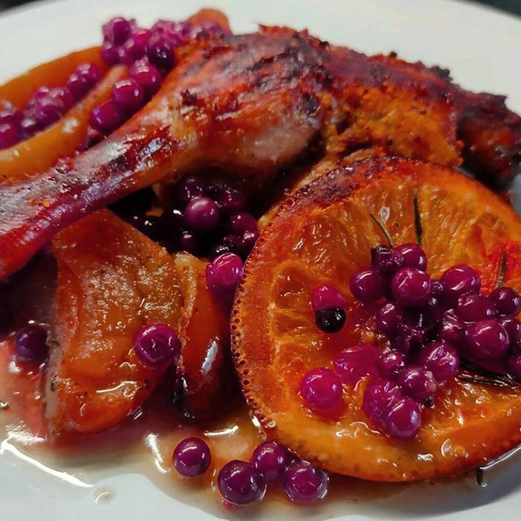 Entenbrüste und -schenkel in Sauce mit Orangen und Äpfeln gebacken