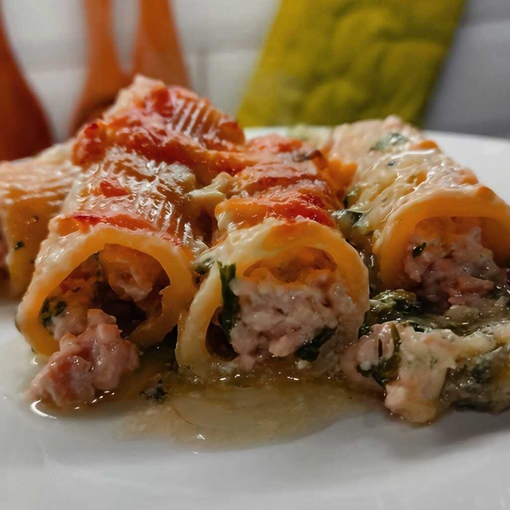 Röhrchen (Cannelloni) mit Hackfleisch auf einem Bett aus Kartoffeln und Spinat